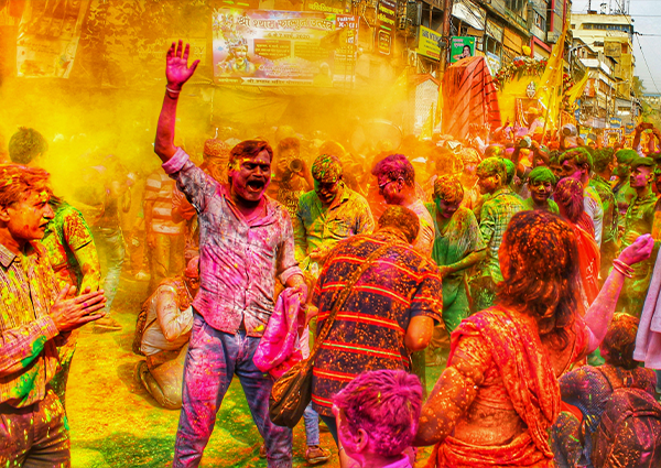 Personas bailando felices en el Festival Holi de India con polvos de colores