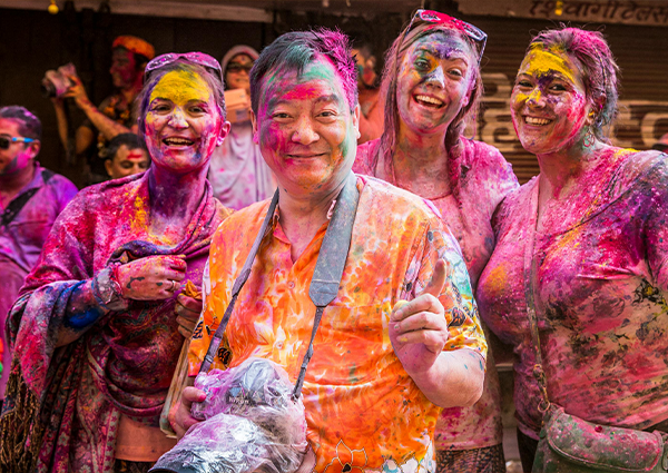 Turistas en el Festival Holi en India celebrando con polvos de colores
